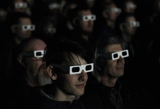 Members of the audience wear 3d glasses while watching German electronic band Kraftwerk perform with a 3d stage set at the Tate Modern in London