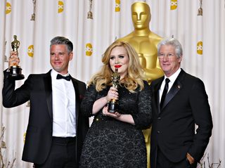 Paul Epworth and Adele Adkins pose with their Oscar for Best Original Song for "Skyfall" with presenter Richard Gere in Hollywood