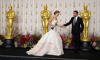 Jennifer Lawrence walks offstage with presenter Jean Dujardin after she won the best actress award at the 85th Academy Awards in Hollywood
