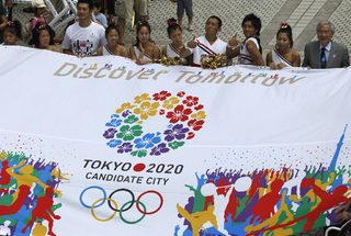Participants hold a banner during an event celebrating Tokyo being chosen to host the 2020 Olympic Games, at Tokyo Metropolitan Government Building in Tokyo