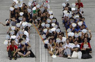 People forming the letter "N", part of a message "THANK YOU", look on during an event celebrating Tokyo being chosen to host the 2020 Olympic Games, in Tokyo