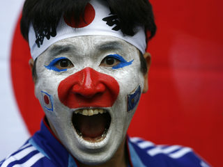 A Japan fan waits in the stands before Japan's match against Brazil in Dortmund