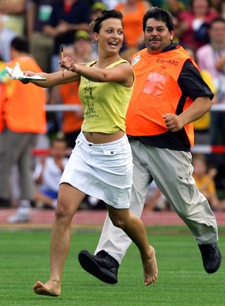 A security guard chases a fan that ran onto the field to get autographs from members of Australia's World Cup soccer team during a public training session in the southern German town of Oehringen
