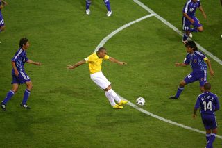 Brazil's Ronaldo scores his team's fourth goal as Japan players watch during their Group F World Cup 2006 soccer match in Dortmund