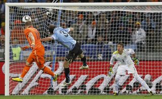 Netherlands' Robben heads in a goal near Uruguay's Godin during their 2010 World Cup semi-final soccer match in Cape Town