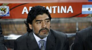 Argentina's head coach Diego Maradona sits on the bench during a 2010 World Cup Group B soccer match against Greece at Peter Mokaba stadium in Polokwane