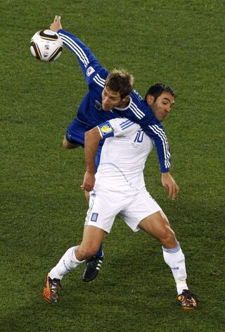 Greece's Karagounis fights for the ball with Argentina's Bolatti during a 2010 World Cup Group B soccer match at Peter Mokaba stadium in Polokwane