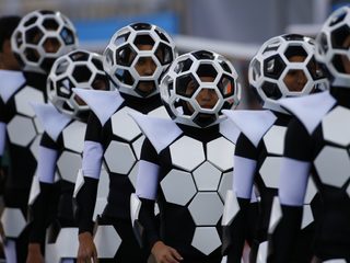 Performers dance in costumes during the 2014 World Cup opening ceremony at the Corinthians arena in Sao Paulo