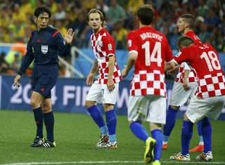 Referee Nishimura gestures to Croatia's national soccer players during their 2014 World Cup opening match against Brazil at the Corinthians arena in Sao Paulo