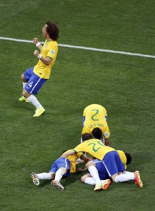 Brazil's players celebrate Oscar's goal during their  2014 World Cup opening match against Croatia at the Corinthians arena in Sao Paulo