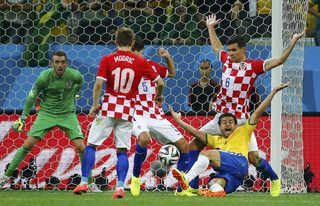 Brazil's Fred reacts as he is fouled by Croatia's Lovren during their 2014 World Cup opening match at the Corinthians arena in Sao Paulo