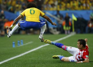 Brazil's Marcelo jumps as Croatia's Ivan Perisic slides beside him during their 2014 World Cup opening match at the Corinthians arena in Sao Paulo