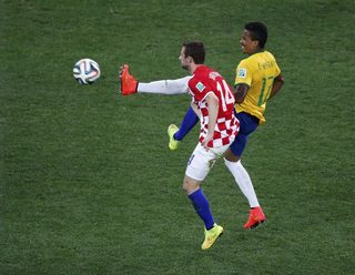Croatia's Brozovic fights for the ball with Brazil's Gustavo during the 2014 World Cup opening match at the Corinthians arena in Sao Paulo