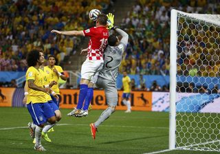 Brazil's Cesar and Croatia's Olic jump for the ball during their 2014 World Cup opening match at the Corinthians arena in Sao Paulo