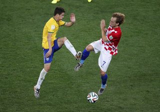 Brazil's Oscar fights for the ball with Croatia's Ivan Rakitic during the 2014 World Cup opening match at the Corinthians arena in Sao Paulo