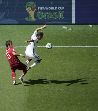 Portugal's Fabio Coentrao fights for the ball with Germany's Mesut Ozil during their 2014 World Cup Group G soccer match at the Fonte Nova arena