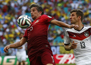 Portugal's Fabio Coentrao and Germany's Thomas Mueller fight for the ball during their 2014 World Cup Group G soccer match at the Fonte Nova arena in Salvador