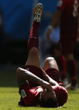 Portugal's Hugo Almeida falls on the ground injured during their 2014 World Cup Group G soccer match against Germany at the Fonte Nova arena in Salvador