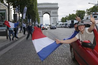 France team soccer fans wave a flag to celebrate on the Champs Elysees after the 2014 World Cup round of 16 game between France and Nigeria at the Brasilia national stadium in Brasilia, in Paris