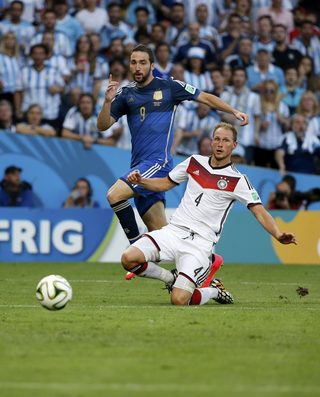 Germany's Benedikt Hoewedes and Argentina's Gonzalo Higuain go for the ball during their 2014 World Cup final at the Maracana stadium in Rio de Janeiro