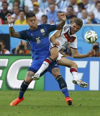 Argentina's Marcos Rojo fights for the ball with Germany's Thomas Mueller during their 2014 World Cup final at the Maracana stadium