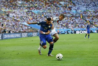 Argentina's Lavezzi fights for the ball with Germany's Mueller during their 2014 World Cup final at the Maracana stadium in Rio de Janeiro