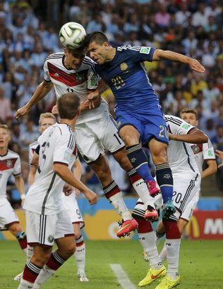 Germany's Klose jumps for the ball with Argentina's Aguero during their 2014 World Cup final at the Maracana stadium in Rio de Janeiro