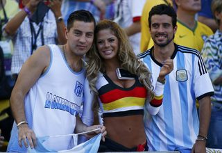 A fan of Germany poses with fans of Argentina as they wait for the start of their 2014 World Cup final at the Maracana stadium in Rio de Janeiro