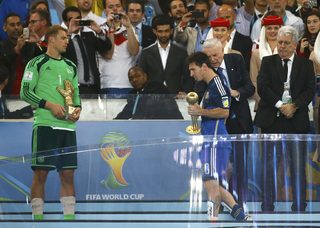 Argentina's Messi holds the Golden Ball trophy as Germany's goalkeeper Neuer holds the Golden Glove trophy after their 2014 World Cup final at the Maracana stadium in Rio de Janeiro