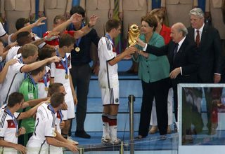 President of FIFA Sepp Blatter and Brazil's President Dilma Rousseff give the World Cup trophy to Germany's Philipp Lahm after they won their 2014 World Cup final against Argentina in Brazil