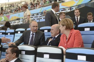 Russian President Putin speaks to German Chancellor Merkel and FIFA President Blatter during the 2014 World Cup final between Germany and Argentina at the Maracana stadium in Rio de Janeiro