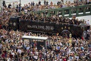 Fans throng street along Spree river to cheer Germany's 2014 Brazil World Cup squad during a parade to mark team's victory in Berlin