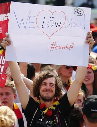 Fans cheer as they wait for the German national soccer team to arrive at 'fan mile' public viewing zone in Berlin