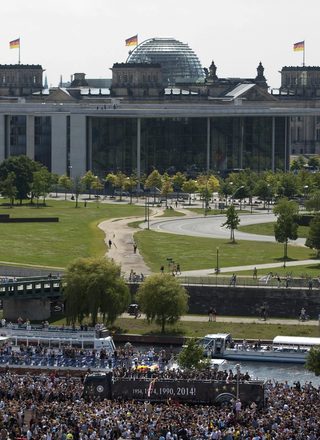 Fans throng street along Spree river to cheer Germany's 2014 Brazil World Cup squad during a parade to mark team's victory in Berlin