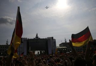 Fans cheer as the plane carrying the German national soccer team, winners of the 2014 World Cup, flies over the 'fan mile' public viewing zone before landing at Tegel airport in Berlin