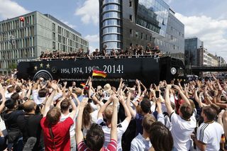 Fans throng street in central Berlin to cheer Germany's 2014 Brazil World Cup squad during a parade to mark team's victory