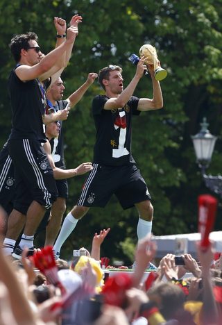 Germany's Mueller holds the World Cup trophy during celebrations to mark team's 2014 Brazil World Cup victory at a 'fan mile' public viewing zone in Berlin