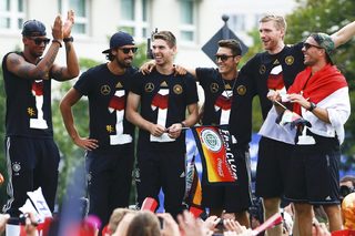 Germany's national soccer team players Boateng, Khedira, Hoewedes, Oezil, Mertesacker and Podolski react on a stage during celebrations to mark the team's 2014 Brazil World Cup victory, at a 'fan mile' public viewing zone in Berlin