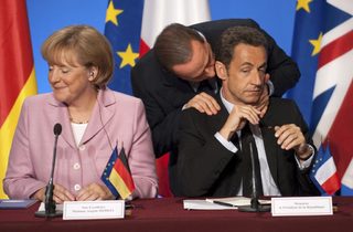 File photo of Italian Prime Minister Berlusconi speaking with France's President Sarkozy and German Chancellor Merkel at Elysee Palace