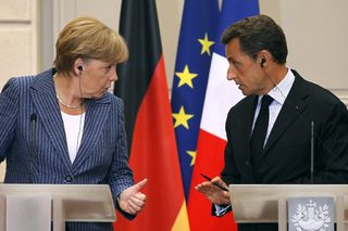 France's President Sarkozy and German Chancellor Merkel talk during a news conference at the Elysee Palace in Paris