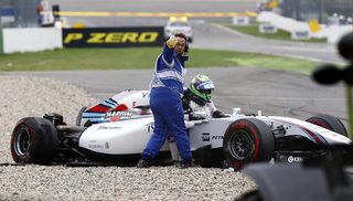 A track marshall gives a thumb up as Williams Formula One driver Massa of Brazil climbs out of the wreckage of his car after crashing in the first corner after the start of the German F1 Grand Prix at the Hockenheim racing circuit