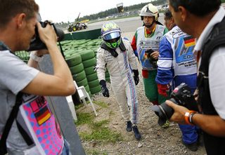 Williams Formula One driver Massa of Brazil walks off the track after crashing with his car in the first corner after the start of the German F1 Grand Prix at the Hockenheim racing circuit