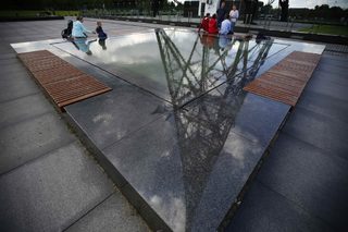 People rest in park in front of the Gliwice radio tower