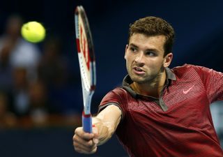 Dimitrov of Bulgaria prepares to return the ball to Federer of Switzerland at the Swiss Indoors ATP tennis tournament in Basel