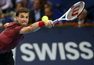 Dimitrov of Bulgaria hits a return to Federer of Switzerland at the Swiss Indoors ATP tennis tournament in Basel
