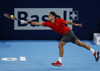 Roger Federer of Switzerland returns the ball to Grigor Dimitrov of Bulgaria at the Swiss Indoors ATP tennis tournament in Basel