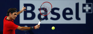 Roger Federer of Switzerland returns the ball to Grigor Dimitrov of Bulgaria at the Swiss Indoors ATP tennis tournament in Basel