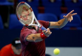 Dimitrov of Bulgaria returns the ball to Pospisil of Canada at the Swiss Indoors ATP tennis tournament in Basel