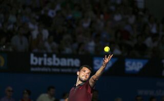 Dimitrov of Bulgaria serves in the afternoon light to Federer of Switzerland during their men's singles semi final at the Brisbane International tennis tournament in Brisbane