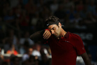 Federer of Switzerland wipes his brow in the afternoon sun during his men's singles semi final win over Dimitrov of Bulgaria at the Brisbane International tennis tournament in Brisbane